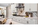 Chef's kitchen features white cabinets, quartz countertops, marble backsplash, and stainless steel appliances at 944 Club Cresswind Dr, Lady Lake, FL 32159