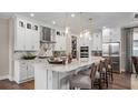 Bright kitchen boasts a large marble island with seating, stainless steel appliances, and an adjacent walk-in pantry at 944 Club Cresswind Dr, Lady Lake, FL 32159