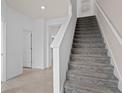 Bright interior showcasing a carpeted staircase with white risers and a hallway leading to other rooms at 10148 Hadley St, Orlando, FL 32829