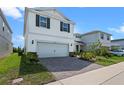 Two-story home showcasing landscaped yard and a brick paved driveway at 10245 Park Estates Ave, Orlando, FL 32836