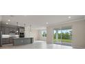 Open-concept kitchen with modern appliances, a center island, and sliding doors leading to patio at 10245 Park Estates Ave, Orlando, FL 32836
