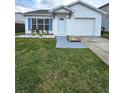 Well-manicured front lawn leading to a charming home with a white exterior and bright blue window shutters at 1025 Clovercrest Rd, Orlando, FL 32811