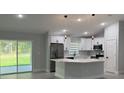 Bright kitchen featuring white cabinets, stainless steel appliances, and a modern island at 10641 Sw 110Th Ct, Dunnellon, FL 34432