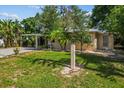 A well-manicured front yard showcases a quaint home with lush green grass and mature trees at 11 Plumosa Ave, Casselberry, FL 32707