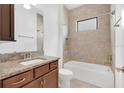 Well-lit bathroom featuring a granite vanity, soaking tub with tile surround, and modern fixtures at 14078 Alafaya Oak Bnd, Orlando, FL 32828