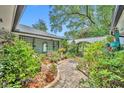 Brick-paved courtyard enhanced by greenery and a white privacy wall with a decorative trellis feature at 1441 Sunnyside Dr, Maitland, FL 32751