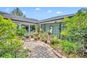 Serene brick-paved courtyard featuring lush landscaping and decorative trellis features for a calming outdoor space at 1441 Sunnyside Dr, Maitland, FL 32751