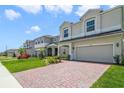 Charming two-story home boasts a well-manicured lawn and a brick driveway leading to a two-car garage at 14655 Erice Ave, Clermont, FL 34714