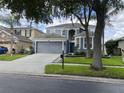Charming two-story home featuring a two-car garage, gray facade, and manicured landscaping at 14936 Masthead Landing Cir, Winter Garden, FL 34787