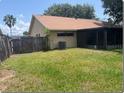 Fenced backyard featuring green lawn, access to screened in porch, and mature trees at 1606 Red Clover Ct, Orlando, FL 32825