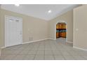 Open-concept living room with neutral paint, tile flooring, and archway to kitchen at 1614 Christa Ct, St Cloud, FL 34772