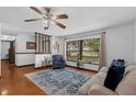 Bright living area featuring wood floors, a large window overlooking the front yard, and a comfortable seating area at 1830 W Clinton Dr, St Cloud, FL 34769