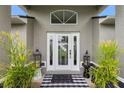 Close up of a charming front door with decorative plants and a welcome mat at 2113 Kirkland Lake Dr, Auburndale, FL 33823