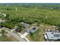 Aerial view of a home with solar panels, a long driveway, and a spacious backyard surrounded by lush greenery at 2135 E Old Mill Dr, Deltona, FL 32725