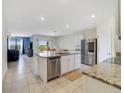 Open-concept kitchen with granite countertops, a kitchen island with seating, and stainless steel appliances at 2135 E Old Mill Dr, Deltona, FL 32725