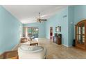 Bright living room featuring light blue walls, tile flooring, and a ceiling fan at 216 Bermuda Petrel Ct, Daytona Beach, FL 32119