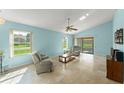 Light-filled living room with tile floors, neutral furniture, and sliding glass doors to the backyard at 216 Bermuda Petrel Ct, Daytona Beach, FL 32119