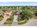 Aerial view of a single-Gathering home with an attached garage next to a beautiful lake and lush landscaping at 2506 Aster Cove Ln, Kissimmee, FL 34758