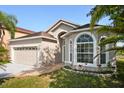 Well-maintained single-Gathering home with an attached garage, landscaped flower bed, and bright windows at 2506 Aster Cove Ln, Kissimmee, FL 34758
