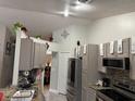 Charming gray kitchen featuring updated appliances, modern backsplash, granite countertops, and an abundance of cabinet storage at 2514 Dovetail Dr, Ocoee, FL 34761