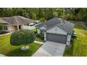 Charming gray home with a two-car garage, landscaped yard, and well-maintained surroundings at 3422 Heath Dr, Deltona, FL 32725