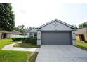 Attractive gray home with a two-car garage, neat landscaping, and inviting curb appeal at 3422 Heath Dr, Deltona, FL 32725