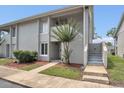 Exterior view showcasing the condo's entrance, landscaping, and stairs to the second level at 5635 Blue Shadows Ct # 3, Orlando, FL 32811