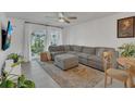 Cozy living room with a large sectional sofa, lots of plants, and natural light from the windows at 5635 Blue Shadows Ct # 3, Orlando, FL 32811