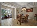 An elegant dining room with natural light, tile floors, and an ornate chandelier above the glass-top table at 5683 Bassett Pl, Sanford, FL 32771