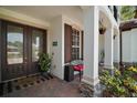 Inviting front porch with decorative columns, a seating area, lush plants, and a charming entrance at 5683 Bassett Pl, Sanford, FL 32771