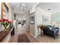 Inviting hallway with wood-look tile flooring, modern light fixture, and open view to the living area at 816 Carmillion Ct, Groveland, FL 34736