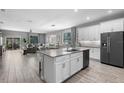 Modern kitchen with an island, stainless steel appliances and an open floor plan leading to living room at 816 Carmillion Ct, Groveland, FL 34736