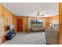 Inviting living room featuring wood paneling, comfortable seating, and a view to the outdoors at 911 Ursula St, Ocoee, FL 34761