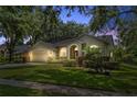 A cozy single-story home showcases its exterior, featuring manicured landscaping and nighttime illumination at 10146 Pointview Ct, Orlando, FL 32836