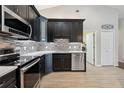 Updated kitchen features sleek black cabinets, stainless steel appliances, and stylish tile backsplash at 10146 Pointview Ct, Orlando, FL 32836