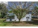 Expansive backyard with a covered patio and mature tree, providing shade and privacy at 11 S University Cir, Deland, FL 32724