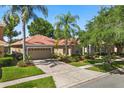 Inviting single-story home with a tile roof, a brick driveway, and manicured landscaping at 11316 Rapallo Ln, Windermere, FL 34786