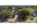 Stunning aerial view of a two-story home with mature trees, solar panels, and a brick driveway at 1254 Shelter Rock Rd, Orlando, FL 32835