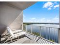 Serene balcony with two lounge chairs overlooking a scenic waterfront view, ideal for relaxation at 13415 Blue Heron Beach Dr # 1503, Orlando, FL 32821