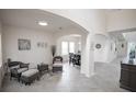 Bright living room with tile floors, large windows, neutral decor, and arched doorways to the rest of the home at 14572 Black Quill Dr, Winter Garden, FL 34787