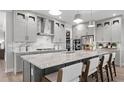 Contemporary kitchen with a spacious island, stainless steel range hood, and sleek gray cabinetry at 1613 Bellagio Loop, Tavares, FL 32778