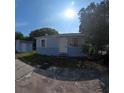 Exterior view of home featuring blue paint, white door, and detached shed on a sunny day at 2031 Warrens Ave, Maitland, FL 32751