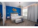Stunning bedroom features a plush bed, elegant lighting, and a striking blue accent wall at 2379 Distant Sun Trl, Kissimmee, FL 34747