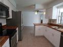 Bright kitchen featuring white cabinets and stainless steel appliances at 2632 Derbyshire Rd, Maitland, FL 32751