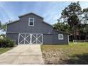 Spacious gray barn with double doors, offering ample storage or workshop potential on the property at 2659 Hibbard Trl, Chuluota, FL 32766