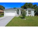Charming single-story home featuring a well-manicured lawn and attached two-car garage at 2710 Autumn Ln, Eustis, FL 32726