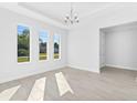 Bright dining room with large windows, tile floors, and a modern chandelier at 304 N Jungle Rd, Geneva, FL 32732