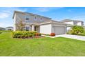 Beautifully landscaped front yard with lush green grass and colorful flower beds at 356 Quarry Rock Cir, Kissimmee, FL 34758