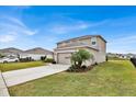 Two-story home with a well-kept lawn, a two-car garage, and a clean driveway on a sunny day at 356 Quarry Rock Cir, Kissimmee, FL 34758