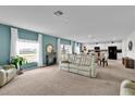 Bright, open living space features a comfortable recliner sofa, large windows, and views of the lake at 356 Quarry Rock Cir, Kissimmee, FL 34758